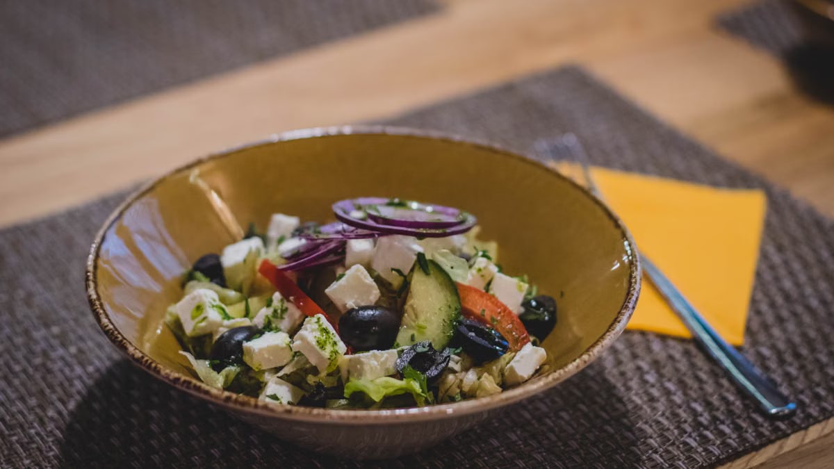 A delicious Greek salad featuring feta cheese, olives, and fresh vegetables in a rustic bowl.